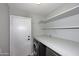 Laundry room with front loading washer/dryer and storage shelf at 10628 W Country Club Trl, Peoria, AZ 85383