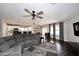 Spacious living room with hardwood floors, large sectional couch, and view of the kitchen at 10628 W Country Club Trl, Peoria, AZ 85383