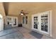 Covered patio with ceiling fan, glass table, and white-framed glass doors to the interior at 10628 W Country Club Trl, Peoria, AZ 85383