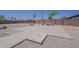 Spacious backyard featuring a concrete patio, basketball hoop, and cozy fire pit area at 10655 E Broadway Rd, Mesa, AZ 85208