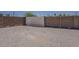 Vast backyard has a chain link gate surrounded by a brick wall and a wide foundation of gravel at 10655 E Broadway Rd, Mesa, AZ 85208