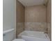 Bathroom featuring a shower/bathtub combo with tan tile surround and toilet at 10655 E Broadway Rd, Mesa, AZ 85208
