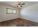 Bright bedroom with wood-look floors, a ceiling fan, and a window with blinds at 10655 E Broadway Rd, Mesa, AZ 85208