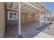 Covered patio with concrete flooring shows access to the expansive backyard with a door to the interior at 10655 E Broadway Rd, Mesa, AZ 85208