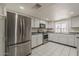 Bright kitchen with stainless steel appliances, white cabinets, and modern tile flooring at 10655 E Broadway Rd, Mesa, AZ 85208