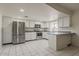 Well-lit kitchen with stainless steel appliances, white cabinets and tile flooring at 10655 E Broadway Rd, Mesa, AZ 85208