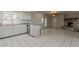 Kitchen with white cabinetry and tile flooring opening to the brick fireplace living area at 10655 E Broadway Rd, Mesa, AZ 85208
