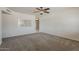 Bright living room with plush carpet, ceiling fan and a view into the adjacent kitchen at 10655 E Broadway Rd, Mesa, AZ 85208