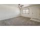 Bright living room with plush carpeting, a ceiling fan, and a window providing natural light at 10655 E Broadway Rd, Mesa, AZ 85208