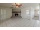 Bright living room with brick fireplace, tile floor and ceiling fan at 10655 E Broadway Rd, Mesa, AZ 85208