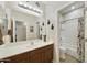 Well-lit bathroom featuring a shower-tub combination, vanity, and a large mirror at 1141 W Stephanie Ln, San Tan Valley, AZ 85143