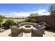 Outdoor fire pit with seating and beautiful desert landscaping at 1141 W Stephanie Ln, San Tan Valley, AZ 85143