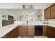 Modern kitchen featuring granite countertops, stainless steel sink, and an open view into the living area at 1141 W Stephanie Ln, San Tan Valley, AZ 85143