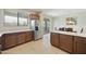 Bright kitchen with granite countertops, stainless refrigerator, and breakfast bar with view into dining area at 1141 W Stephanie Ln, San Tan Valley, AZ 85143
