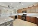 Well-lit kitchen boasts granite countertops, stainless appliances, and convenient pass-through to the living area at 1141 W Stephanie Ln, San Tan Valley, AZ 85143