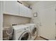 Functional laundry room with washer, dryer, and ample storage cabinets at 1141 W Stephanie Ln, San Tan Valley, AZ 85143