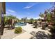 Beautiful backyard pool and spa with mature palm trees and desert landscaping at 1141 W Stephanie Ln, San Tan Valley, AZ 85143