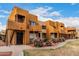Exterior view of multiple units with balconies and decorative rock landscaping in a desert setting at 11640 N 51St Ave # 211, Glendale, AZ 85304