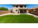 Spacious backyard with artificial grass and a covered patio area at 11841 W Laurel Ln, El Mirage, AZ 85335