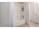 Clean and functional bathroom with a shower-tub combination, white tiles, and modern fixtures at 11841 W Laurel Ln, El Mirage, AZ 85335