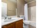 Bathroom with a white sink and toilet and tiled shower with curtain at 11841 W Laurel Ln, El Mirage, AZ 85335