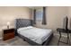 Bedroom featuring a queen-size bed with a gray tufted headboard and carpet flooring at 11841 W Laurel Ln, El Mirage, AZ 85335