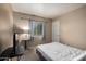 Neutral bedroom with carpet flooring, a window with gray curtains, and a white door at 11841 W Laurel Ln, El Mirage, AZ 85335