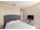 Bedroom featuring a queen-size bed with gray headboard and a wall-mounted television at 11841 W Laurel Ln, El Mirage, AZ 85335