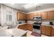 Functional kitchen with oak cabinets, stainless steel appliances, and a view of a window for natural light at 11841 W Laurel Ln, El Mirage, AZ 85335