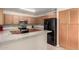 Well-equipped kitchen featuring wood cabinets, black appliances, and lots of counter space for meal preparation at 11841 W Laurel Ln, El Mirage, AZ 85335