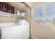 Laundry room with washer, dryer, and shelving next to a window at 11841 W Laurel Ln, El Mirage, AZ 85335