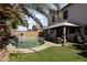 This backyard features a sparkling pool, artificial turf and a covered patio with seating at 12814 W Edgemont Ave, Avondale, AZ 85392