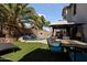 Inviting backyard features artificial turf, a pool and a patio with dining area at 12814 W Edgemont Ave, Avondale, AZ 85392