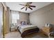 This bedroom includes a ceiling fan, bedside table, bed, and neutral paint at 12814 W Edgemont Ave, Avondale, AZ 85392