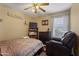 Cozy bedroom with ceiling fan, dresser, bookcase, and comfortable leather recliner at 12814 W Edgemont Ave, Avondale, AZ 85392