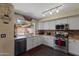 Bright kitchen with white cabinets, stainless steel appliances, and an exposed brick backsplash at 12814 W Edgemont Ave, Avondale, AZ 85392
