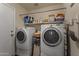 Functional laundry room includes washer, dryer, and storage shelves at 12814 W Edgemont Ave, Avondale, AZ 85392