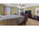 This main bedroom features two windows, a ceiling fan, and matching furniture at 12814 W Edgemont Ave, Avondale, AZ 85392