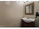Updated powder room vanity with decorative mirror and stylish fixtures at 12814 W Edgemont Ave, Avondale, AZ 85392