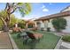 Inviting backyard with lounge chairs on artificial grass and an inviting shade tree on a sunny day at 13131 N 153Rd Ave, Surprise, AZ 85379