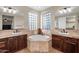 Bright bathroom with a soaking tub surrounded by glass block windows and dual vanities at 13131 N 153Rd Ave, Surprise, AZ 85379