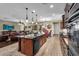 Modern kitchen featuring dark cabinets, island and stainless steel appliances, adjacent to the living area at 13131 N 153Rd Ave, Surprise, AZ 85379