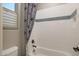 Cozy bathroom with white subway tiles, decorative accent stripe, and a tub/shower combo at 14979 S 184Th Ave, Goodyear, AZ 85338