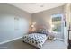 Charming bedroom with a pink upholstered bed, side tables, and window with neighborhood view at 14979 S 184Th Ave, Goodyear, AZ 85338