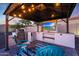 This outdoor kitchen in the gazebo includes seating, a TV, and a grill, perfect for entertaining at 14979 S 184Th Ave, Goodyear, AZ 85338