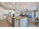 Open-concept kitchen featuring a large island, stainless steel appliances, and an adjoining living area at 14979 S 184Th Ave, Goodyear, AZ 85338