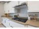 Gourmet kitchen featuring white cabinets, stainless steel range hood, and sleek countertops at 14979 S 184Th Ave, Goodyear, AZ 85338