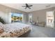Large main bedroom featuring a ceiling fan, carpeted floors, and views of the outdoor pool area at 14979 S 184Th Ave, Goodyear, AZ 85338