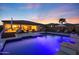 Gorgeous swimming pool with custom lighting, an umbrella, and an inviting patio with lounge chairs at 14979 S 184Th Ave, Goodyear, AZ 85338