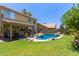 Beautiful backyard featuring a pool with rock features, a covered patio, and a lush green lawn at 1560 E Flint St, Chandler, AZ 85225